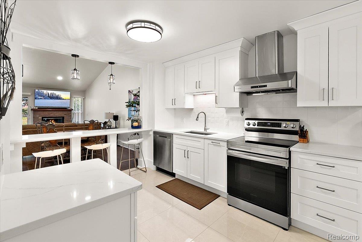 552 Tennyson Rochester, MI 48307 - Photo 12 of 36 Modern kitchen featuring white shaker cabinetry, stainless steel appliances, white countertops, and a subway tile backsplash