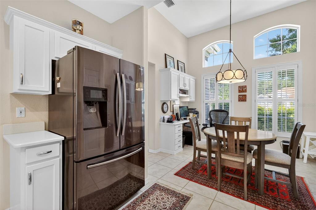 13536 Southeast 97th Terrace Road Summerfield, FL 34491 - Photo 6 of 34 a kitchen with stainless steel appliances granite countertop a dining table chairs refrigerator and sink