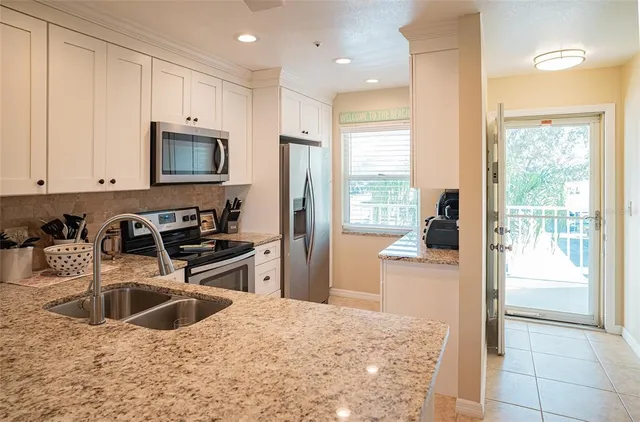 a kitchen with granite countertop a sink stove and refrigerator