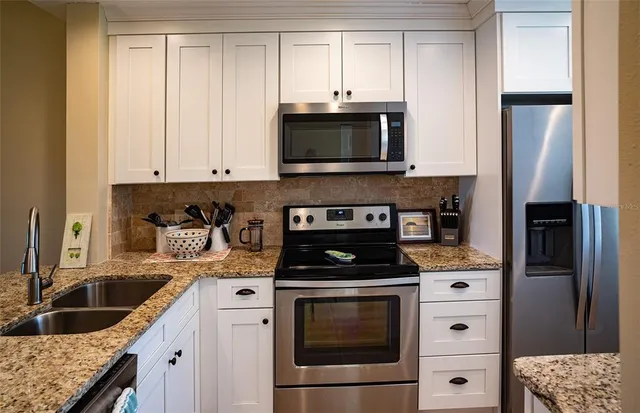 a kitchen with a sink appliances and cabinets