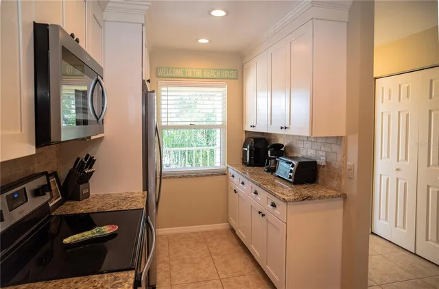 a kitchen with kitchen island granite countertop a sink cabinets and stainless steel appliances