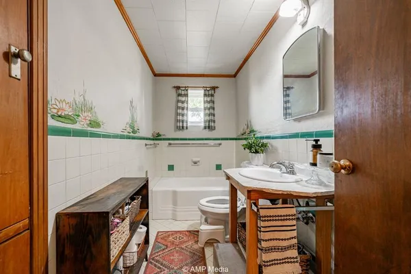 a bathroom with a sink a toilet and mirror
