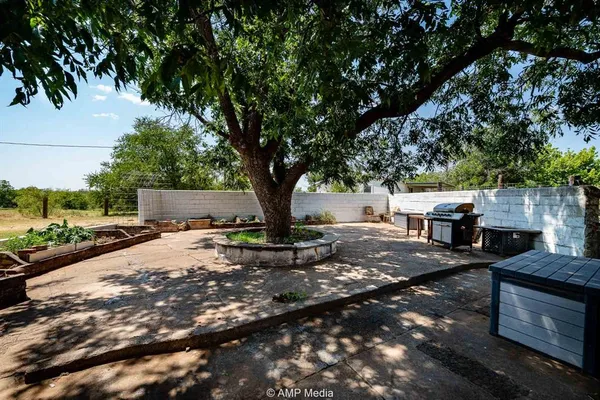 a view of backyard with outdoor seating and trees