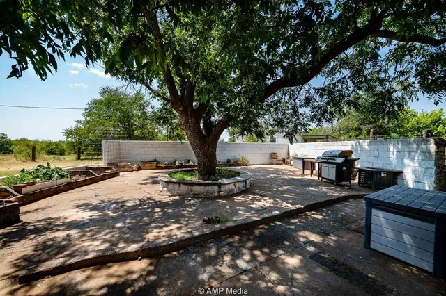 a view of backyard with outdoor seating and trees