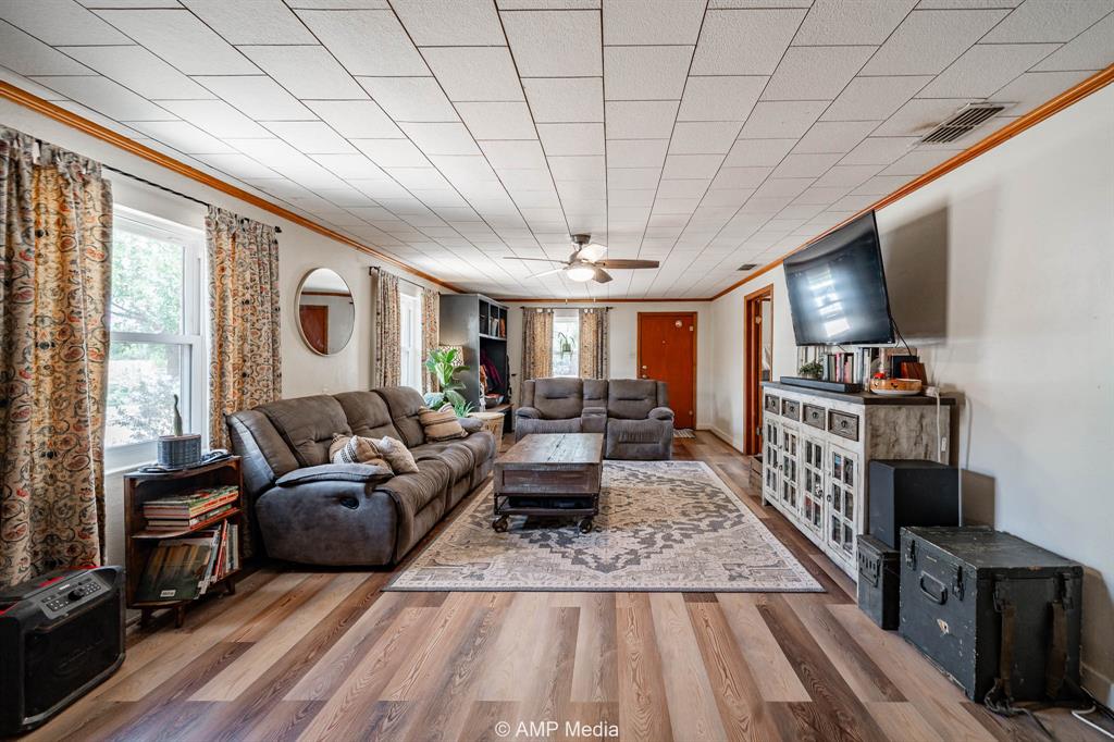 130 County Road 104 Roby, TX 79543 - Photo 6 of 39 a living room with furniture a flat screen tv and a floor to ceiling window