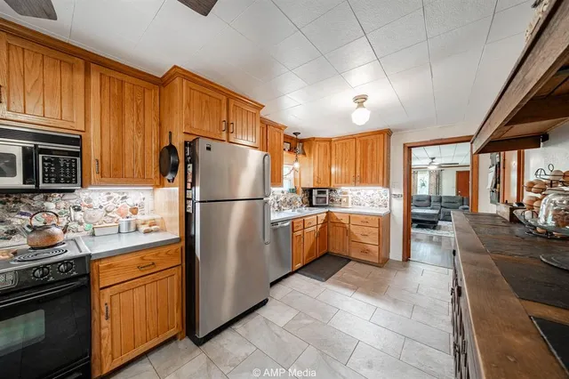 a kitchen with granite countertop a refrigerator stove top oven and sink