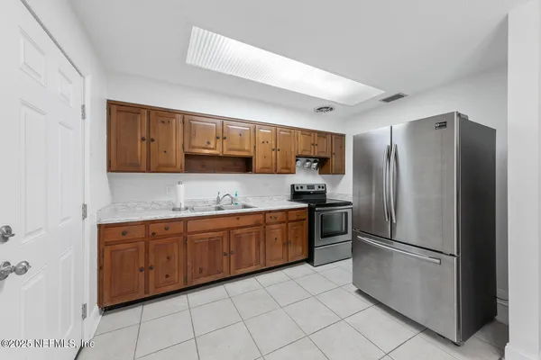 a kitchen with stainless steel appliances granite countertop a stove a sink dishwasher and a refrigerator with wooden floor
