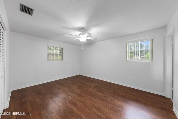 a view of a kitchen with a refrigerator and wooden floor