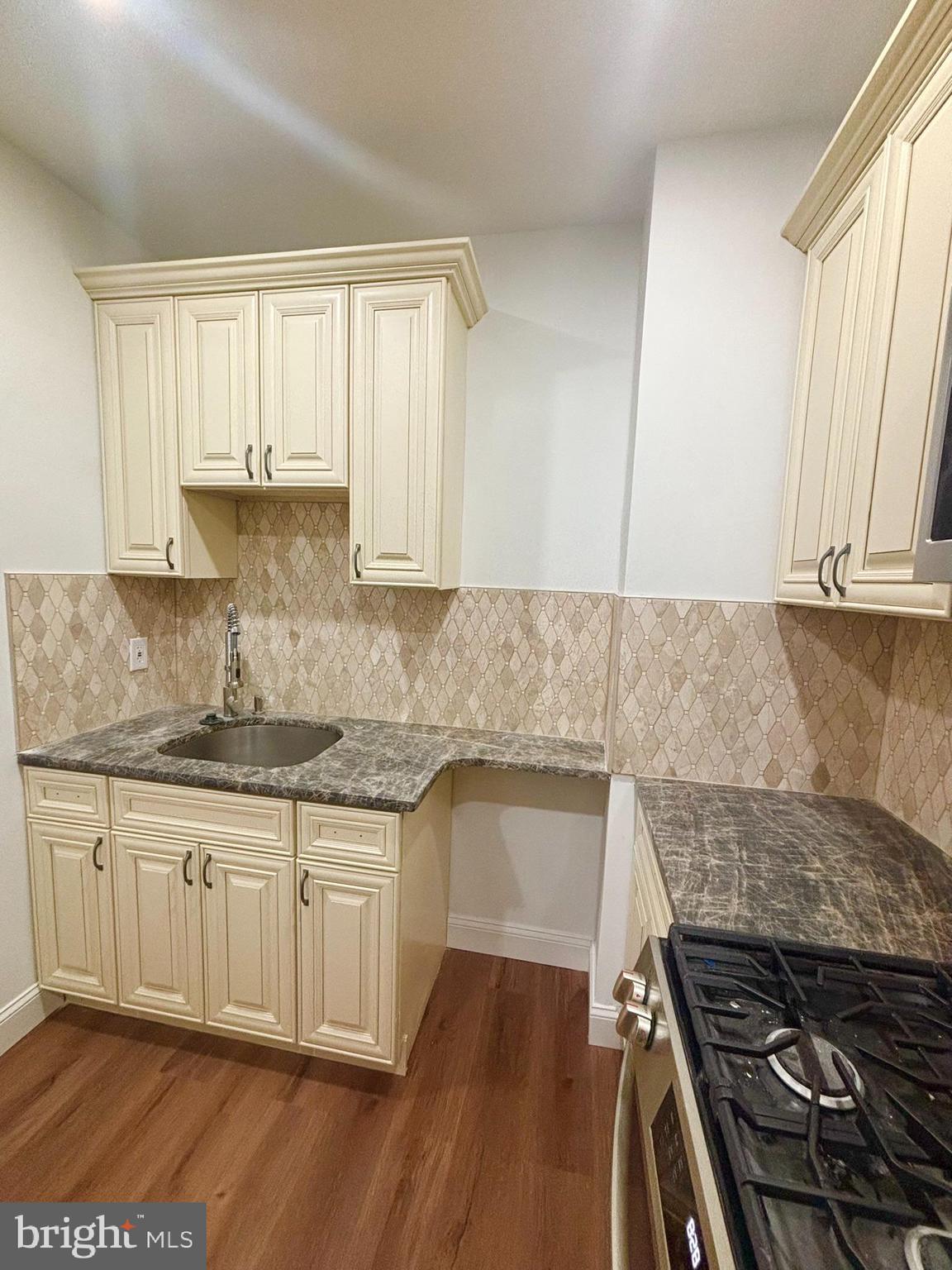 320 Loney Street, Unit (2ND FL) Philadelphia, PA 19111 - Photo 4 of 19 a kitchen with granite countertop a stove and white cabinets