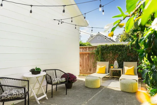 a view of a patio with chairs and potted plants