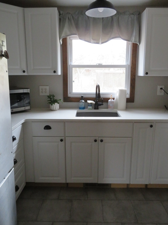 34 R Pine Street Norton, MA 02766 - Photo 10 of 20 a kitchen with white cabinets a sink and dishwasher
