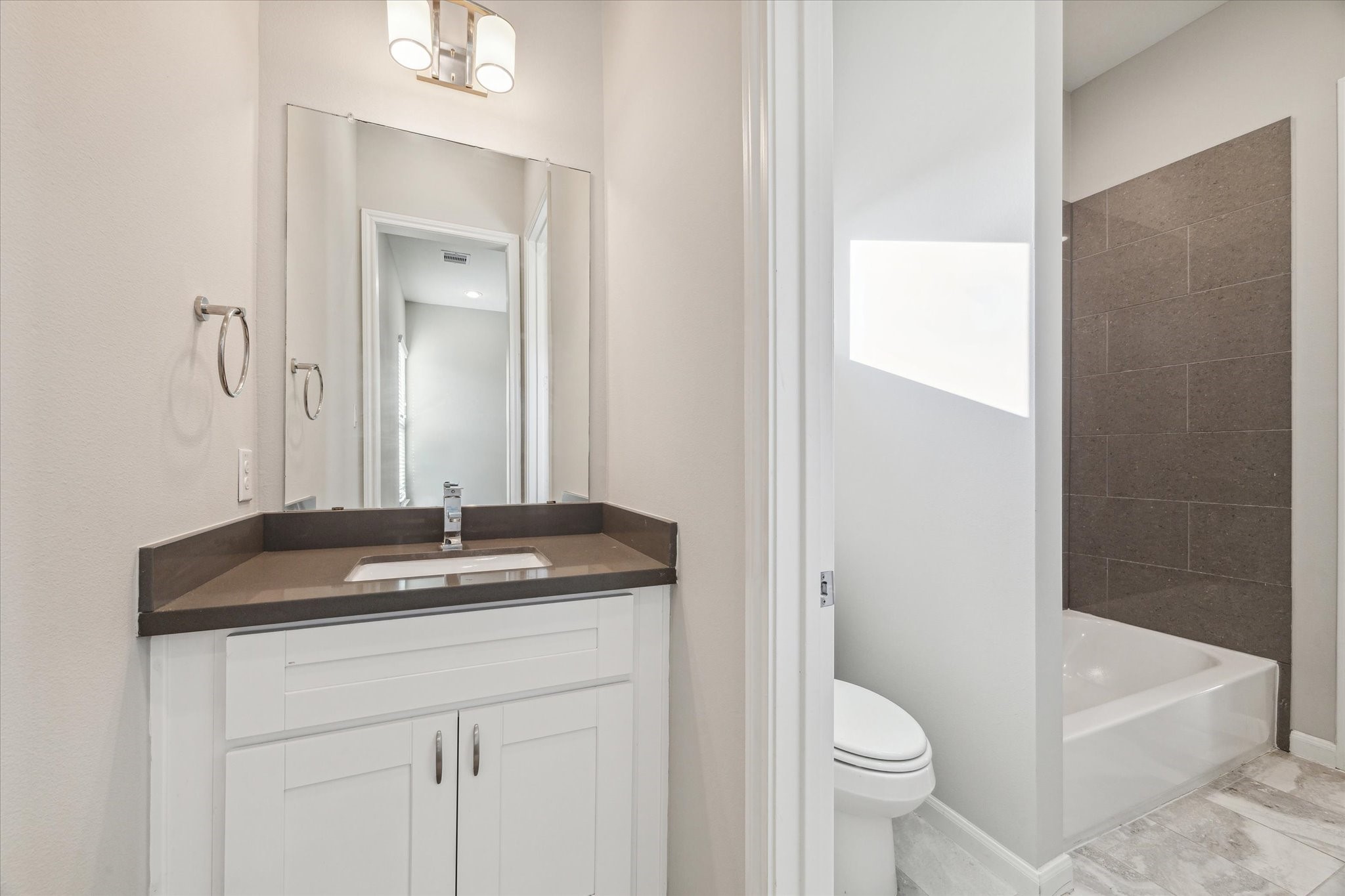 5610 Patrick Street, Unit A Houston, TX 77076 - Photo 9 of 11 a bathroom with a granite countertop sink toilet and shower