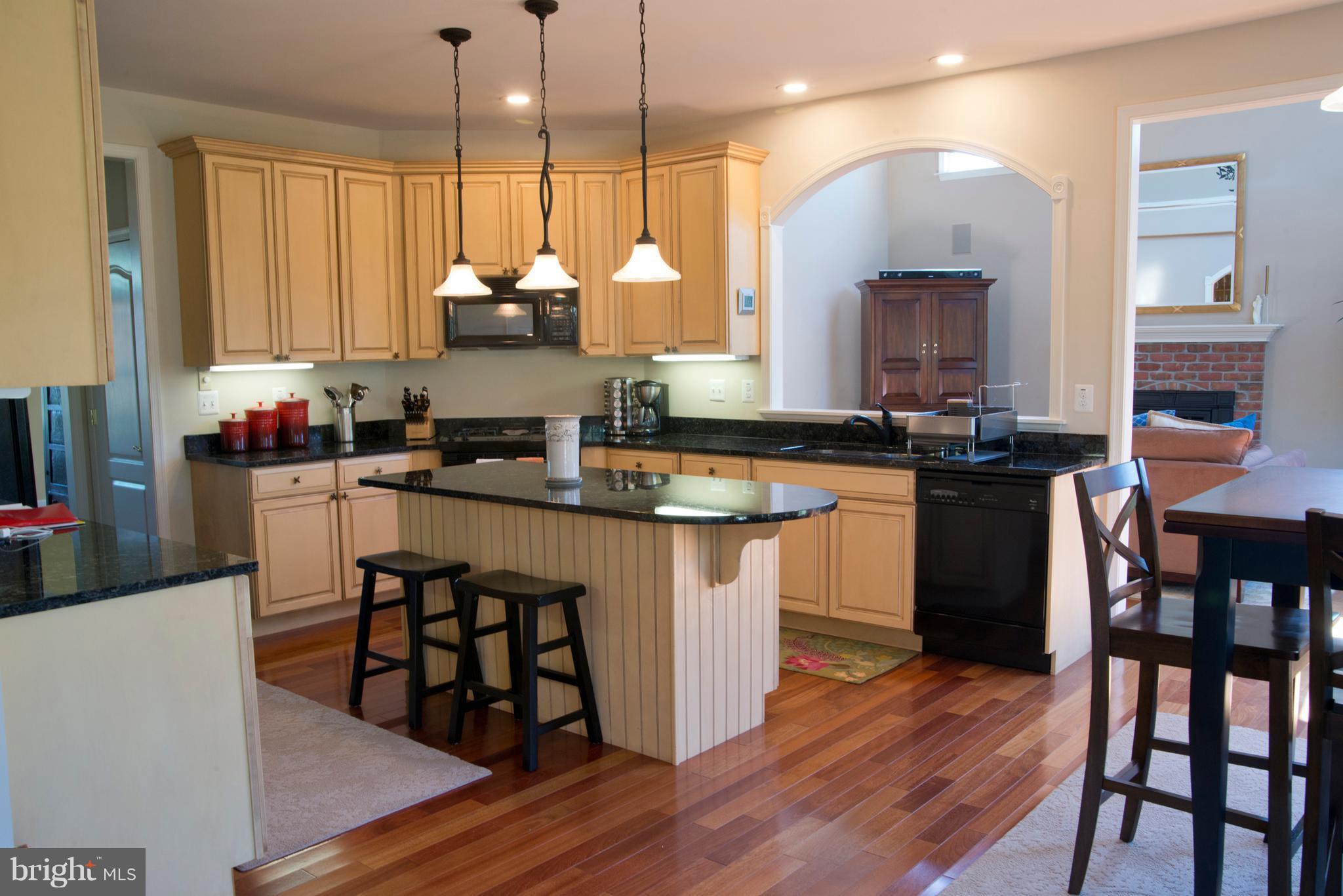 Kit. Island w/pendant lights + granite counters