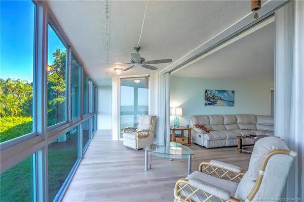 a living room with furniture a flat screen tv and a large window