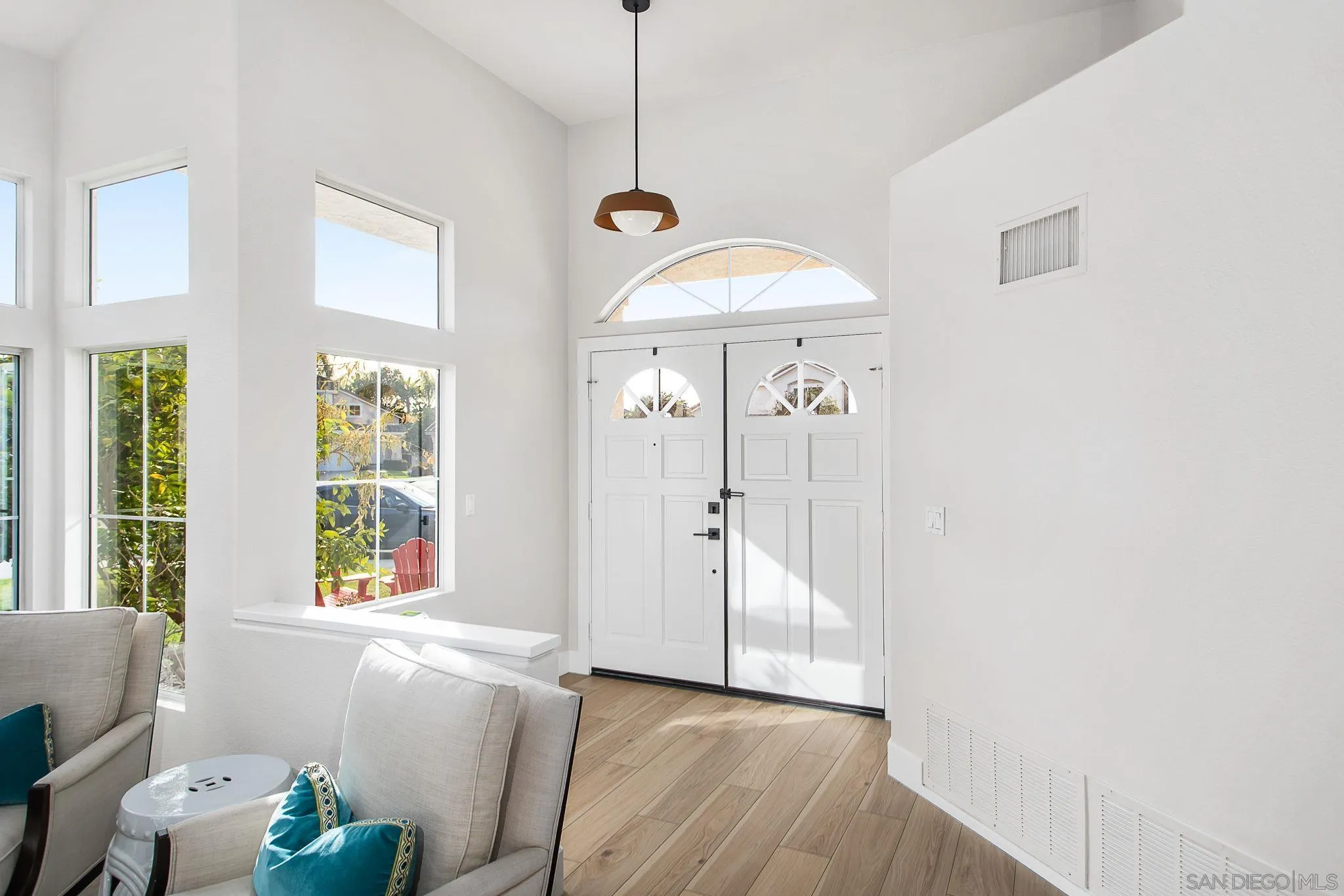 649 Mosaic Circle Oceanside, CA 92057 - Photo 2 of 52 a view of a hallway with wooden floor and a chandelier