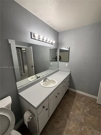 a spacious bathroom with a sink toilet and mirror