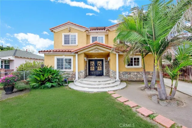 a front view of a house with a garden and yard
