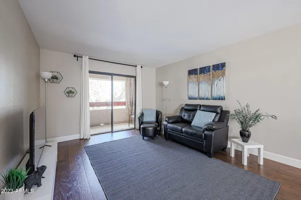 a living room with furniture and a wooden floor