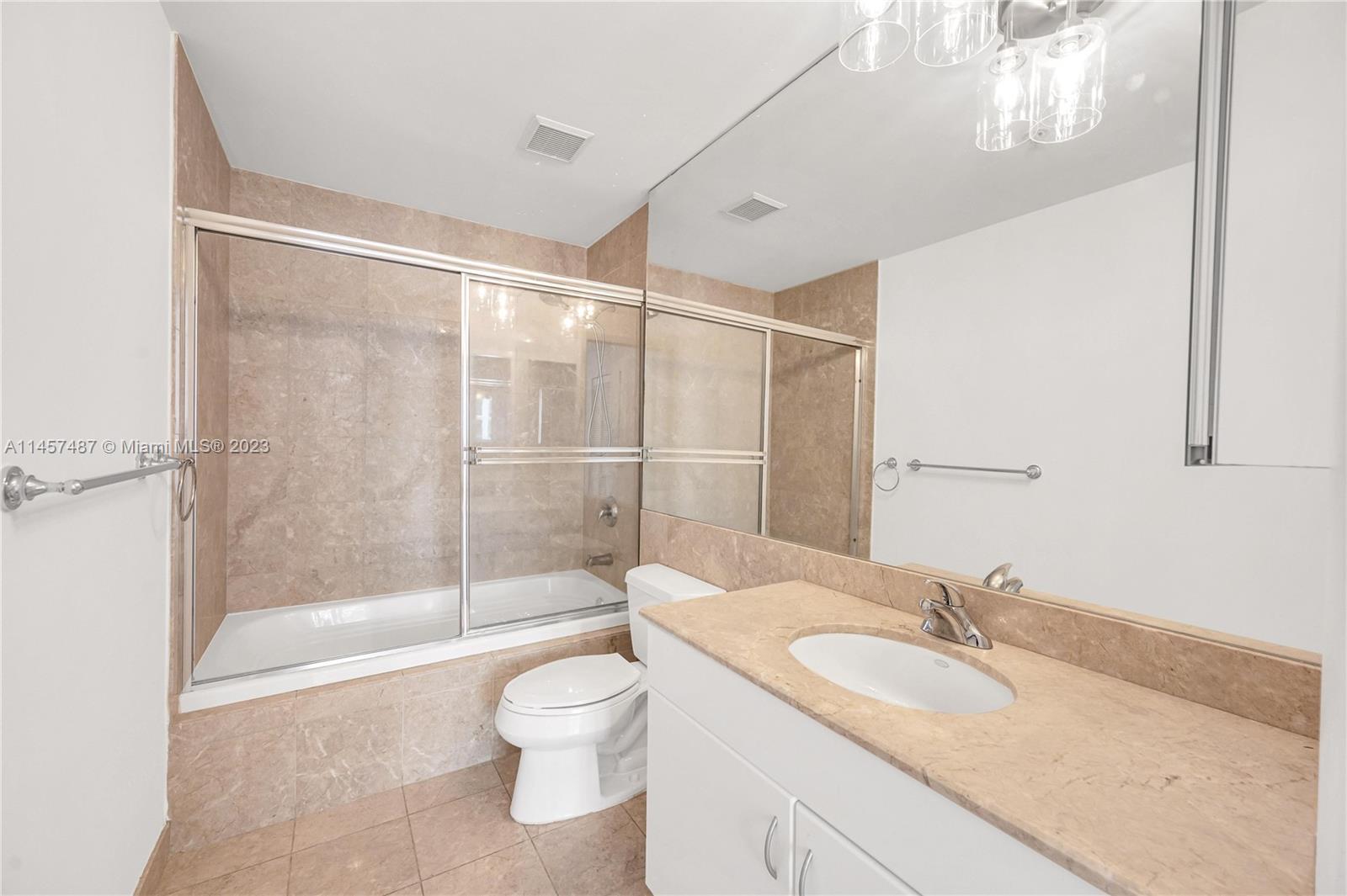 801 Brickell Key Boulevard, Unit 2208 Miami, FL 33131 - Photo 12 of 22 a bathroom with a granite countertop sink toilet and shower