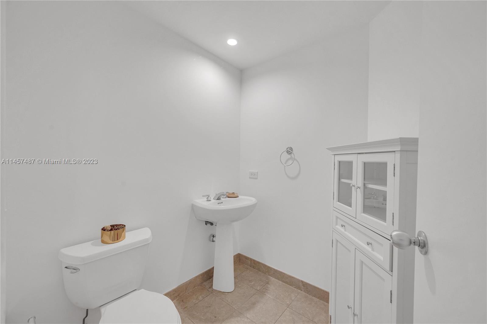 801 Brickell Key Boulevard, Unit 2208 Miami, FL 33131 - Photo 14 of 22 a bathroom with a sink a toilet and a mirror