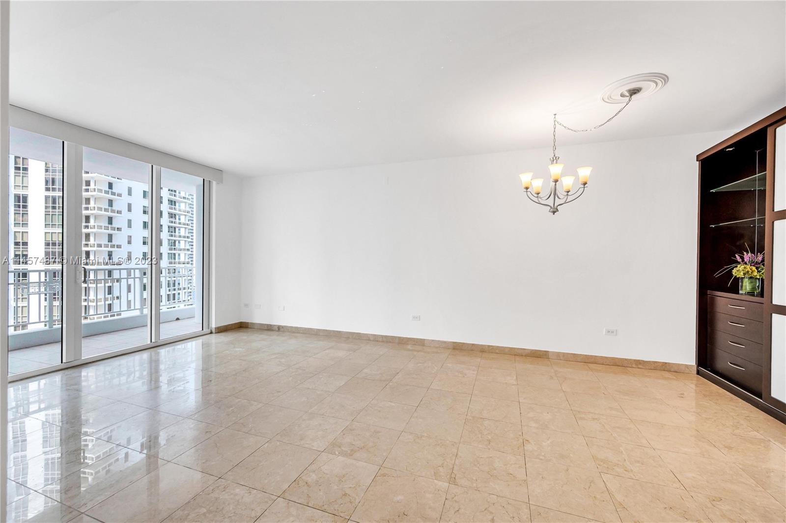 801 Brickell Key Boulevard, Unit 2208 Miami, FL 33131 - Photo 7 of 22 an empty room with chandelier fan and windows