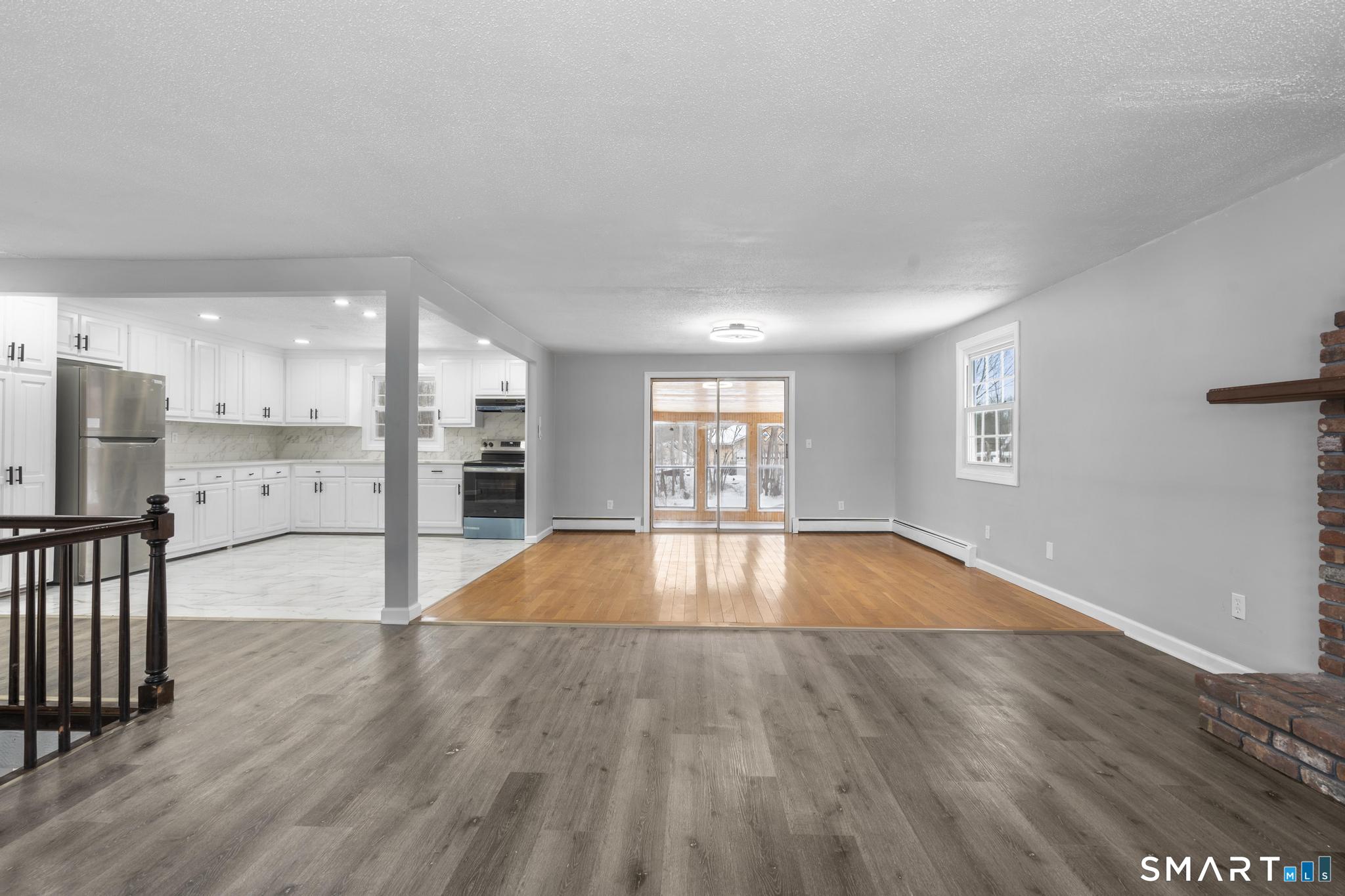 133 Phelps Road East Windsor, CT 06088 - Photo 14 of 40 a view of empty room with wooden floor and kitchen