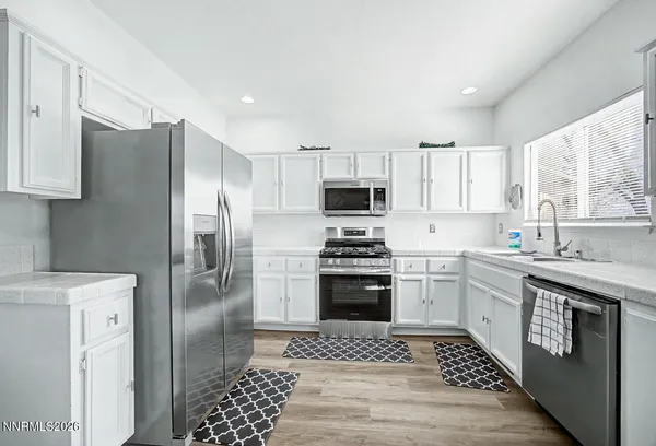 a kitchen with stainless steel appliances granite countertop a refrigerator sink and stove