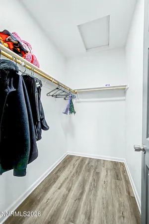 a view of walk in closet with clothes and shoes