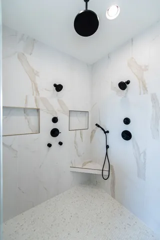 an empty room with wooden floor a kitchen view and a fireplace