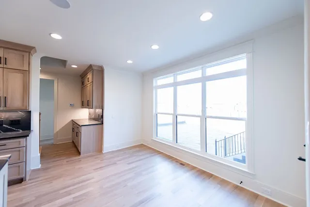 a view of empty room with wooden floor