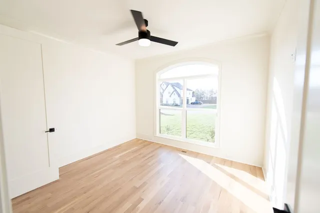 a view of empty room with wooden floor