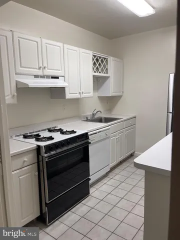 a kitchen with granite countertop white cabinets and white appliances