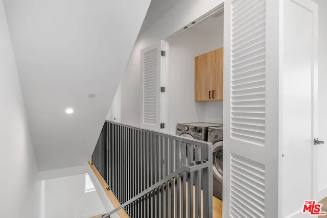 a view of staircase with railing and white walls