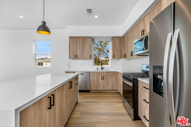 a kitchen with stainless steel appliances granite countertop a refrigerator a stove top oven a sink and dishwasher