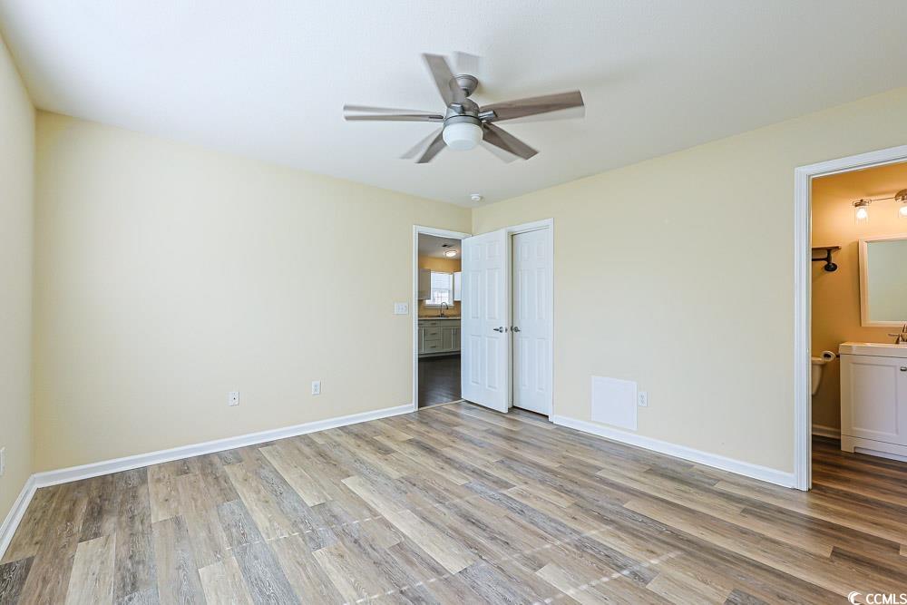 833 Silvercrest Drive Myrtle Beach, SC 29579 - Photo 12 of 30 Unfurnished bedroom featuring ensuite bathroom, ceiling fan, and light wood-style flooring
