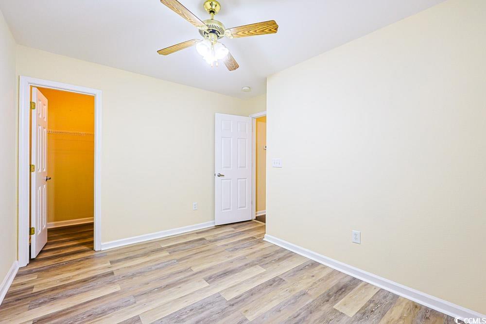 833 Silvercrest Drive Myrtle Beach, SC 29579 - Photo 17 of 30 Unfurnished bedroom featuring a spacious closet, light wood finished floors, and ceiling fan