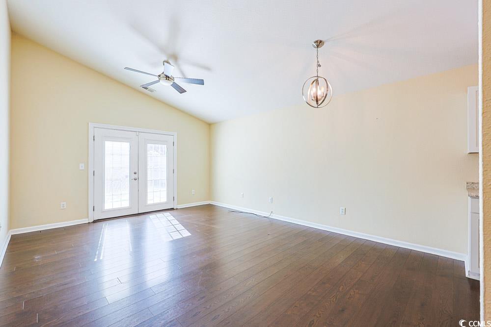 833 Silvercrest Drive Myrtle Beach, SC 29579 - Photo 3 of 30 Unfurnished living room featuring ceiling fan, french doors, lofted ceiling, dark wood-style floors, and a chandelier
