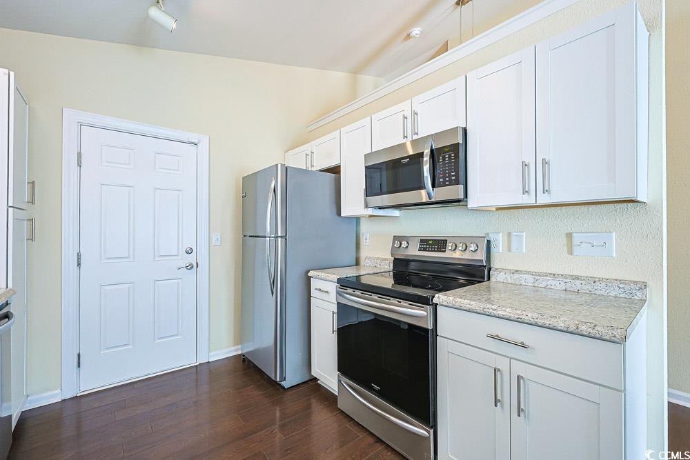 833 Silvercrest Drive Myrtle Beach, SC 29579 - Photo 8 of 30 Kitchen featuring appliances with stainless steel finishes, light countertops, white cabinets, and dark wood finished floors