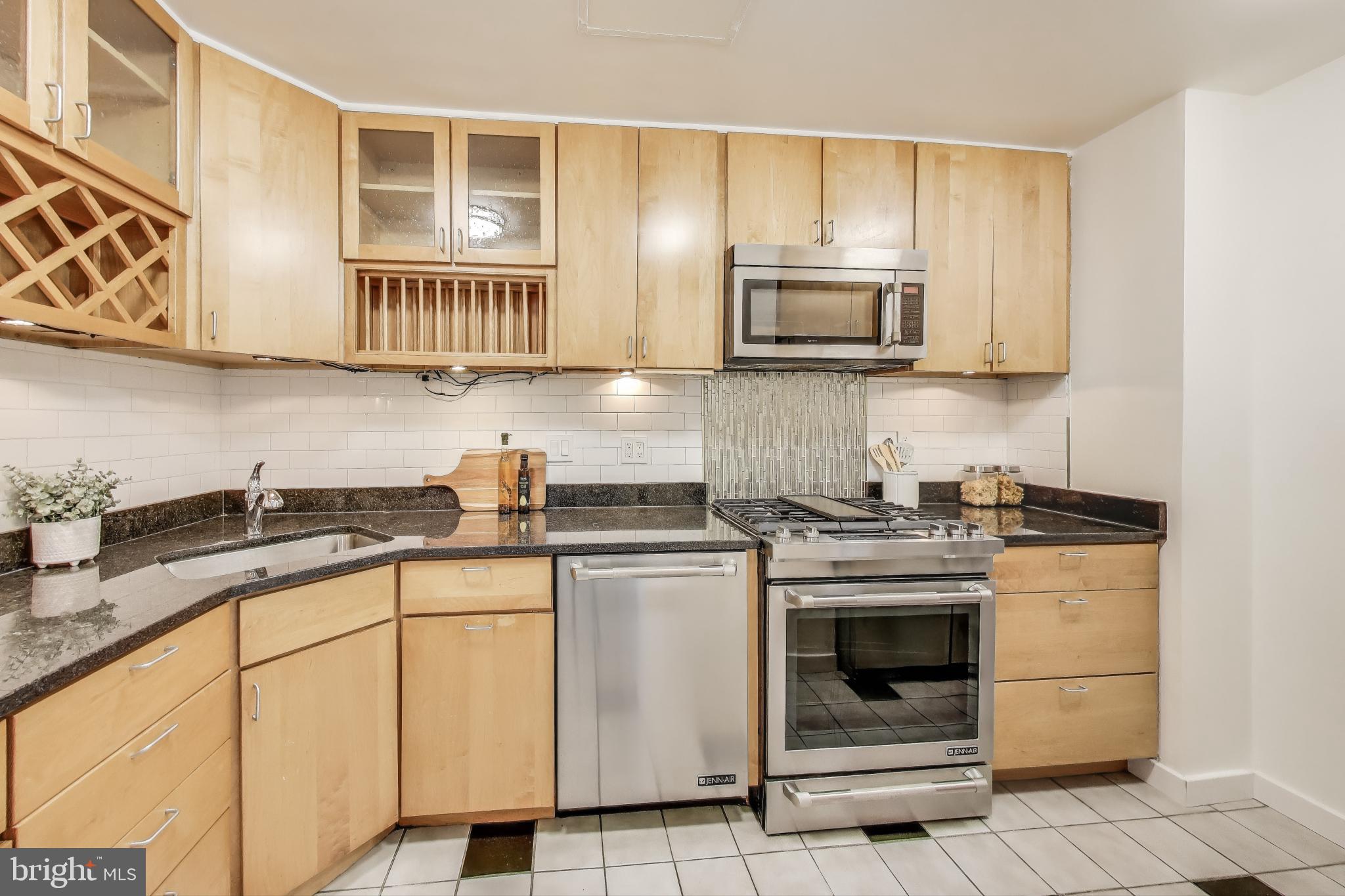 490 M Street Southwest, Unit W802 Washington, DC 20024 - Photo 9 of 23 a kitchen with stainless steel appliances granite countertop a stove a sink and a microwave