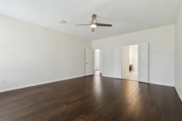 a view of an empty room with wooden floor