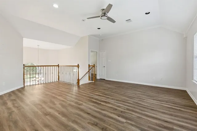 a view of an empty room with wooden floor