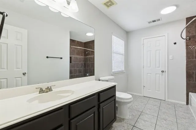 a bathroom with a double vanity sink toilet and a mirror