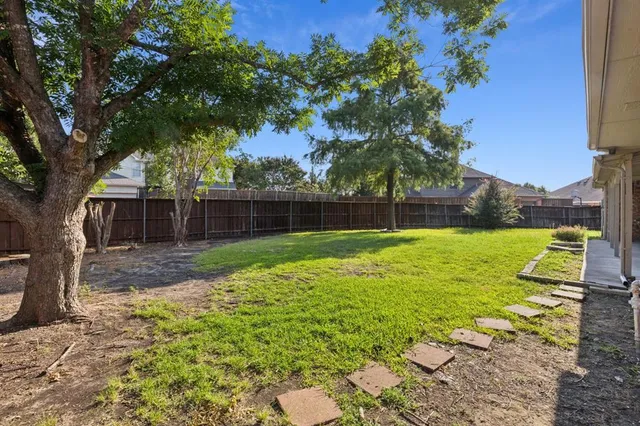 a view of a house with backyard and a tree