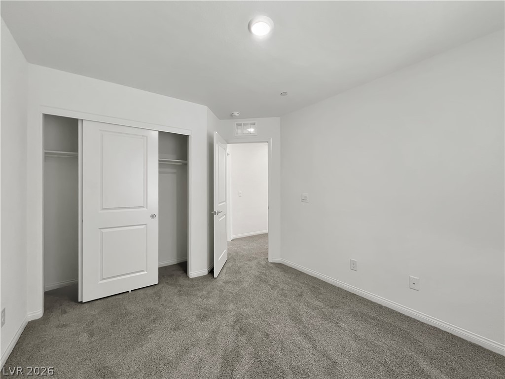 9984 Indigo Cliffs Street Las Vegas, NV 89141 - Photo 21 of 31 Unfurnished bedroom with a closet, baseboards, visible vents, and carpet flooring