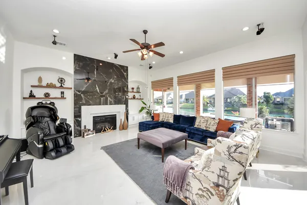 a living room with furniture a fireplace and a floor to ceiling window
