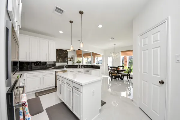 a kitchen with appliances cabinets and chairs