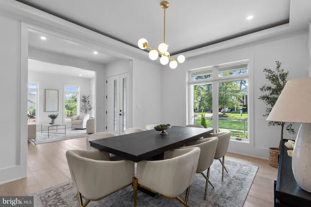 a living room with furniture kitchen view and a chandelier