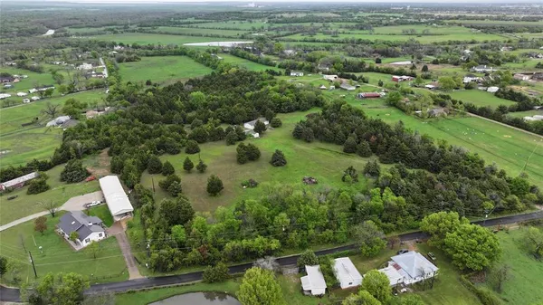 an aerial view of residential houses with outdoor space and trees