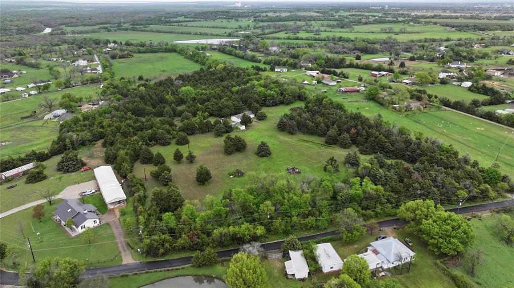 an aerial view of residential houses with outdoor space and trees