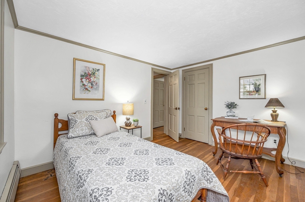 8 Greenwood Road Reading, MA 01867 - Photo 24 of 39 a bedroom with a bed and wooden floor